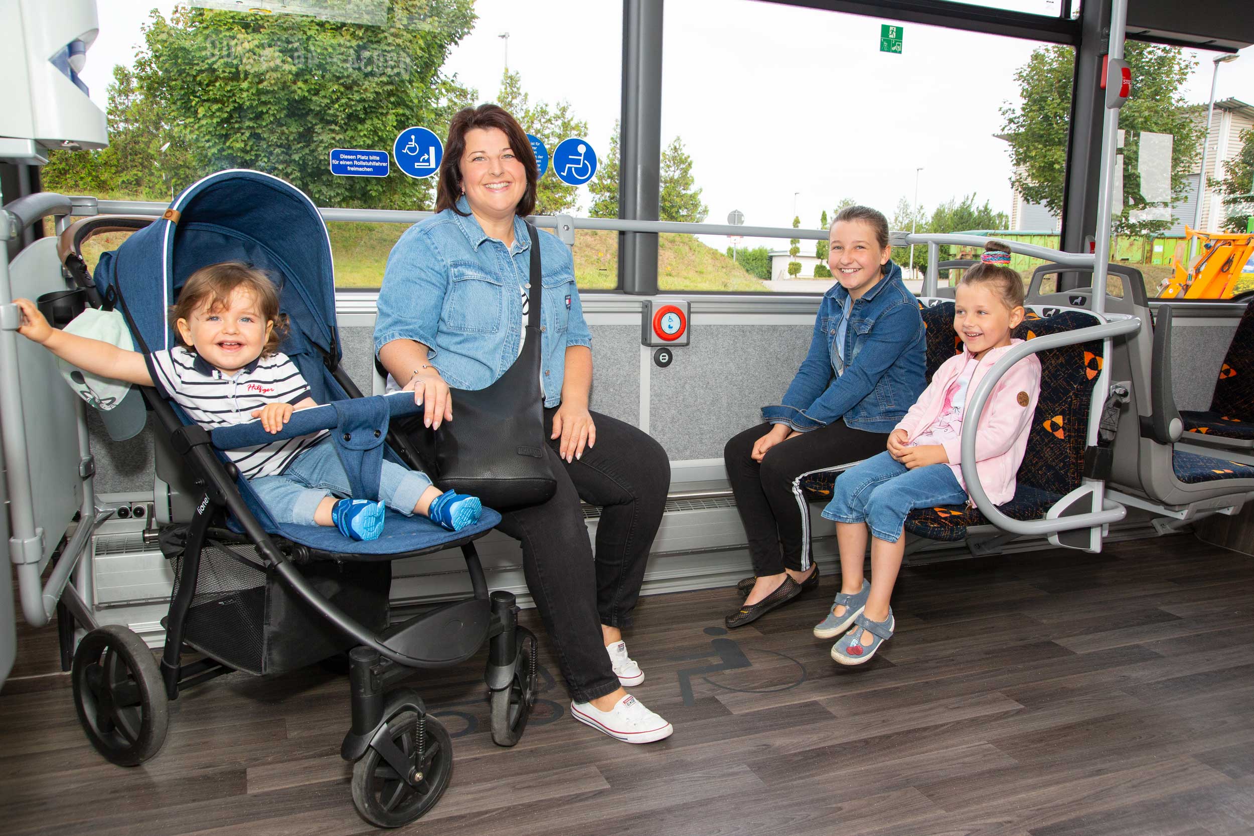 Fröhliche Familie: Mutter mit 3 Kinder im Bus